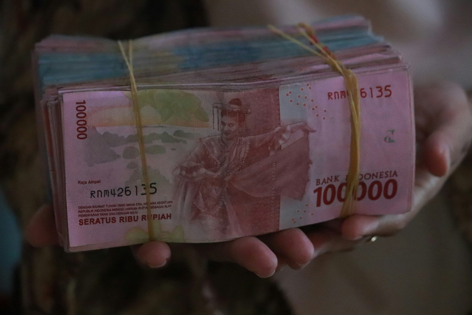 person holding 5000 indonesian rupiah